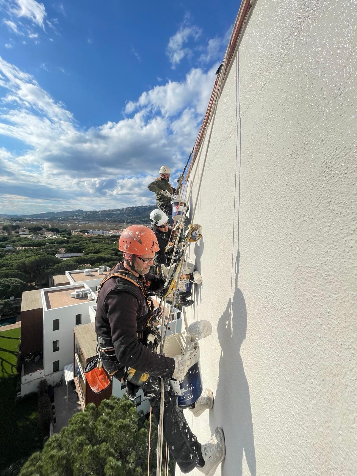 Equipo de técnicos VECO certificados IRATA rehabilitando fachada de edificio en altura