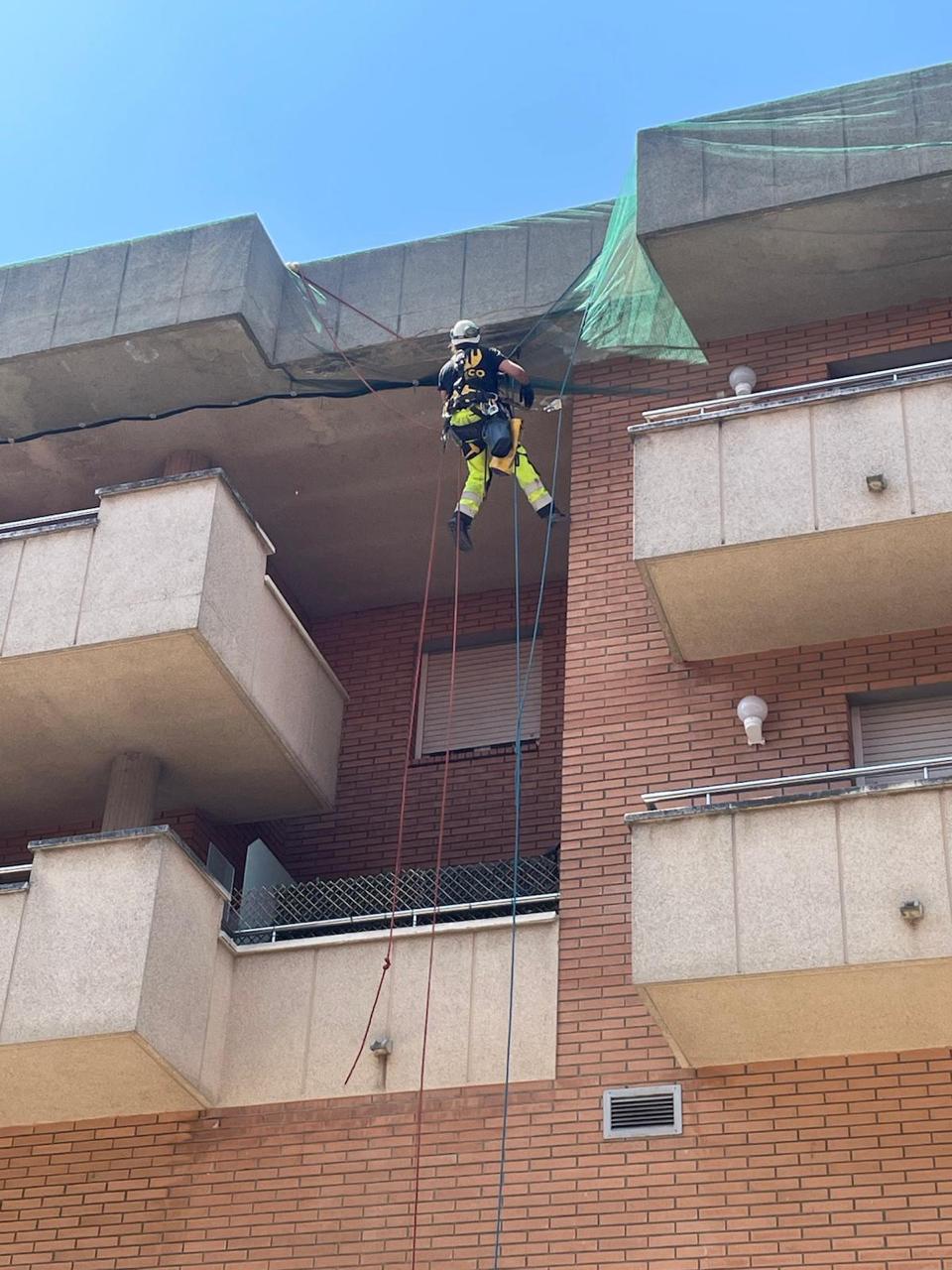Técnico VECO en fachada de ladrillo realizando trabajos verticales con rope access